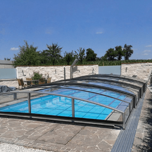 Cubierta telescópica de piscina abierta sobre jardín
