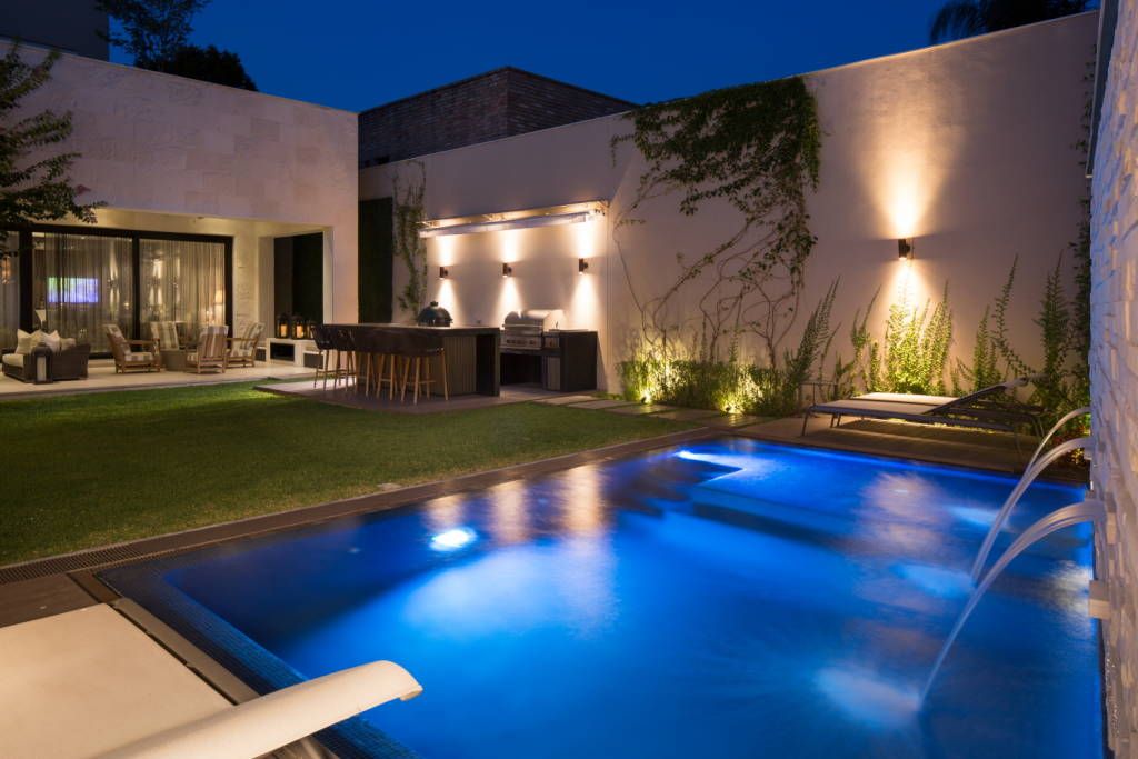 Pérgola bioclimática junto a piscina con zona de descanso